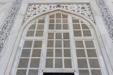 Güzel tasarlanmış mermer kemer penceresi. Detaylı süslemeler ve Tac Mahal 'in renkli mücevherleri. Taj Mahal 1643 yılında Mughal İmparatoru Şah Cihan tarafından karısı Mumtaz Mahal 'in mezarına ev sahipliği yapmak için yaptırılmıştır..
