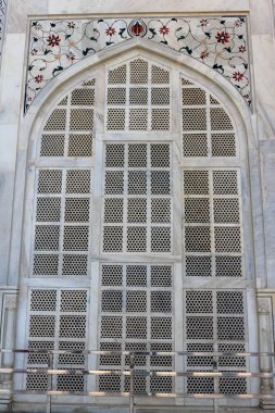 Güzel tasarlanmış mermer kemer penceresi. Detaylı süslemeler ve Tac Mahal 'in renkli mücevherleri. Taj Mahal 1643 yılında Mughal İmparatoru Şah Cihan tarafından karısı Mumtaz Mahal 'in mezarına ev sahipliği yapmak için yaptırılmıştır..