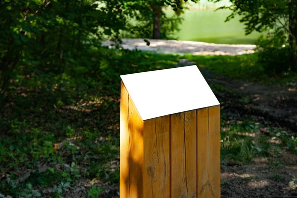Señal de información horizontal en blanco en soporte de madera sobre hierba verde en el parque —  Fotos de Stock