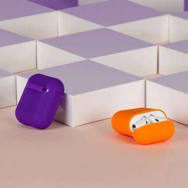 Bej arka plandaki kutuların önünde kablosuz bluetooth kulaklıklar