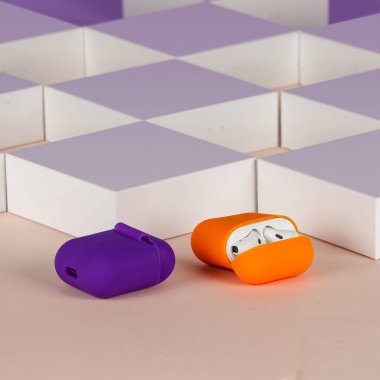 Bej arka plandaki kutuların önünde kablosuz bluetooth kulaklıklar.