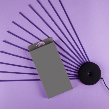 Siyah kablosuz şarj cihazı, mor arkaplandaki cep telefonu için.