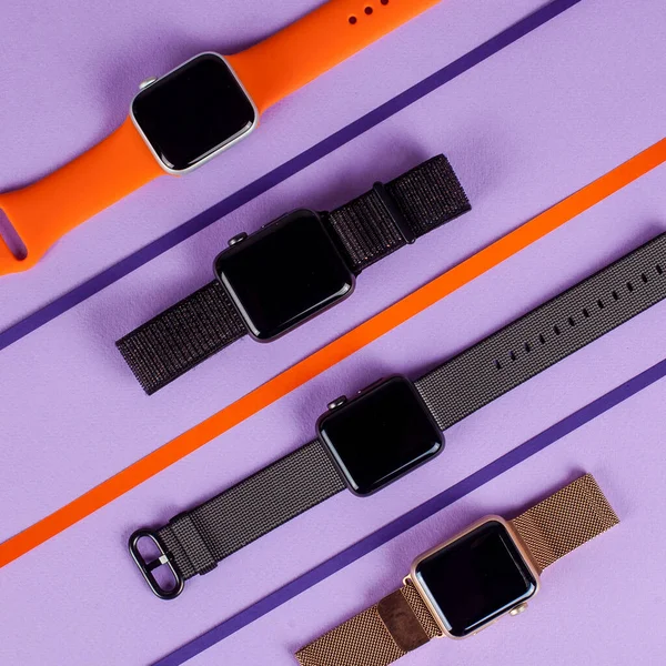 Inteligentní hodinky s různými popruhy na barevném pozadí — Stock fotografie