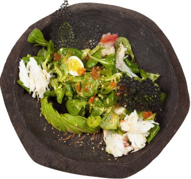 Kırmızı havyarlı salata ve siyah ahşap kasede yengeç. Arka planda izole edilmiş.