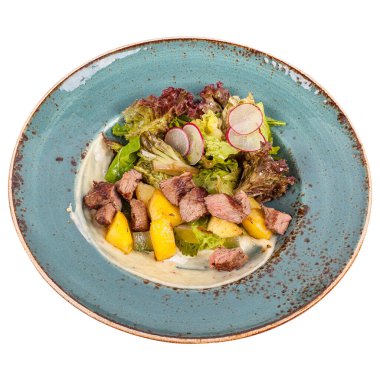 Kızarmış biftekli sulu salata ve kızarmış biberiye patatesli, mavi tabakta baharatlı sos..