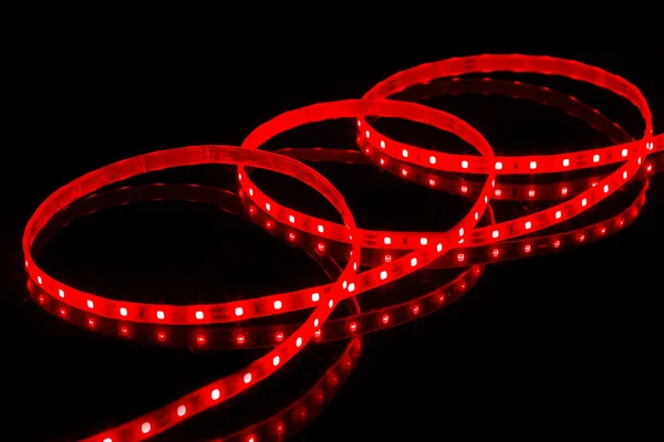 Red LED strip tape on black background.