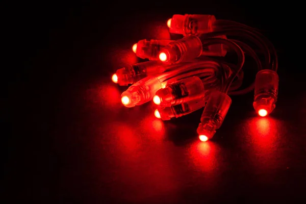 Glowing RED led pixels christmas holiday lights on black background.