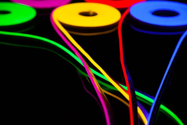 Flessibile nastro led neon flex in diversi colori su sfondo nero . — Foto Stock