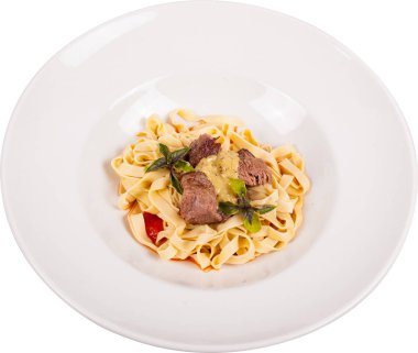Biftekli makarna, beyaz tabakta..