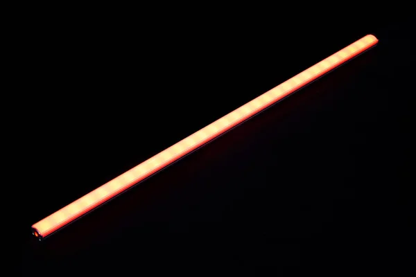 Glowing red led light bar on black background.