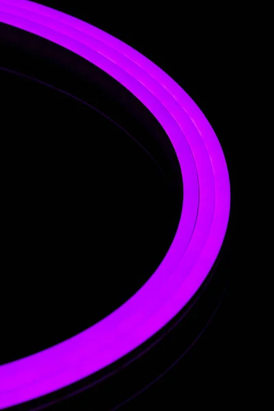 Flexible purple led tape neon flex closeup on black background.