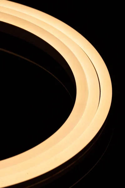 Flexible warmweiße LED-Klebeband Neon Flex Nahaufnahme auf schwarzem Hintergrund. — Stockfoto