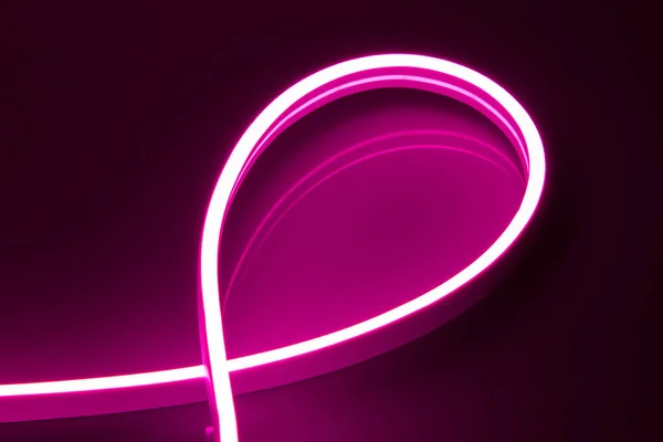 Flexible purple LED neon strip on black background.