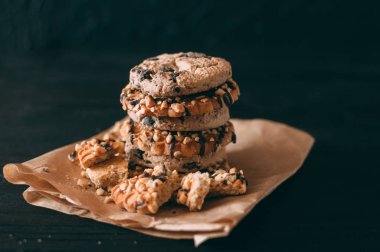 Koyu eski ahşap masa üzerinde çikolata parçacıklı kurabiyeler. Yeni pişirilmiş. Kopyalama alanı ile Seçici Odaklanma.