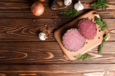 Eski ahşap bir masada tütsülenmiş salam. Biberiye, sarımsak ve biberli sosis.