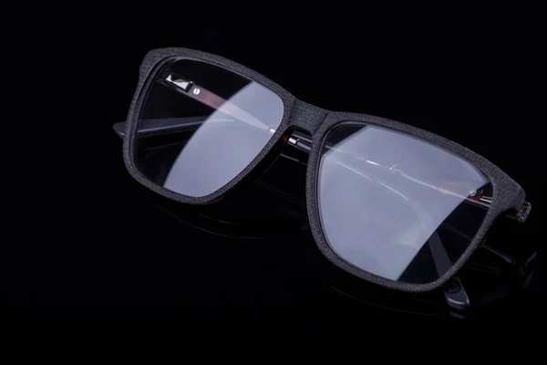 Occhiali eleganti su sfondo nero con un'immagine a specchio . — Foto Stock