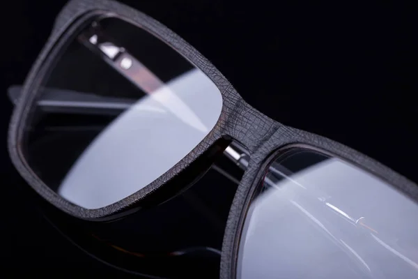 Óculos elegantes em um fundo preto com uma imagem espelhada . — Fotografia de Stock