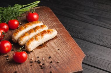 Ahşap bir bac üzerinde kahverengi bir ahşap tahta üzerinde ızgara sosis ızgara