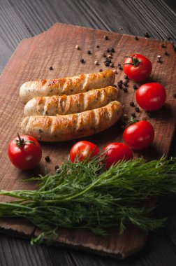 Ahşap bir bac üzerinde kahverengi bir ahşap tahta üzerinde ızgara sosis ızgara