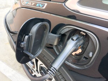 Electric vehicle charging while parked clipart