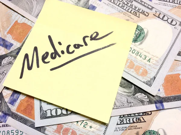 Американские наличные деньги и желтая купюра с текстом Medicare — стоковое фото