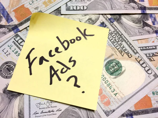 American cash money and yellow paper note with text Facebook Ads question mark — Stock Photo, Image
