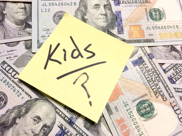 American cash money and yellow post it note avec texte Enfants avec point d'interrogation — Photo