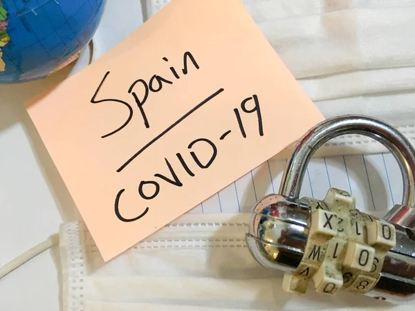 China virus Coronavirus COVID-19 infection Spain lockdown COVID respiratory disease influenza effect on surgical mask and earth globe background
