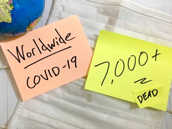 Coronavirus COVID-19 Casos médicos de infección mundial y muertes. China COVID enfermedades respiratorias influenza virus estadísticas mano escrita en máscara quirúrgica y globo terráqueo fondo — Foto de Stock