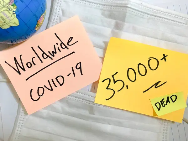Coronavirus COVID-19全球感染病例和死亡。中国COVID呼吸道疾病流感病毒统计数据手写在外科口罩和地球背景上 — 图库照片