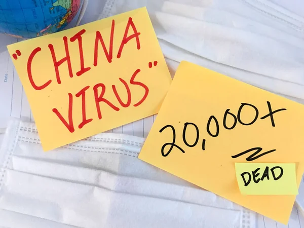 China virus Coronavirus COVID-19 infection medical cases and deaths . COVID respiratory disease influenza statistics hand written on surgical mask and earth globe background