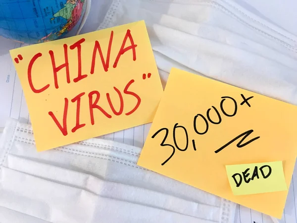 China virus Coronavirus COVID-19 infection medical cases and deaths . COVID respiratory disease influenza statistics hand written on surgical mask and earth globe background