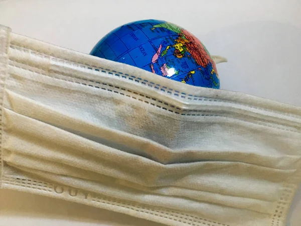 Earth globe wearing covered white surgical mask isolated disease concept epidemic