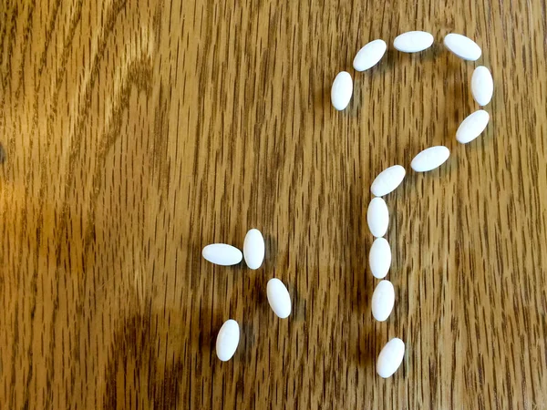 Medicine pills making question mark