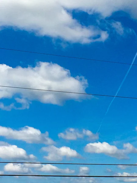 Niebieski niebo białe clounds z linii energetycznych na słoneczny dzień strumień odrzutowy — Zdjęcie stockowe