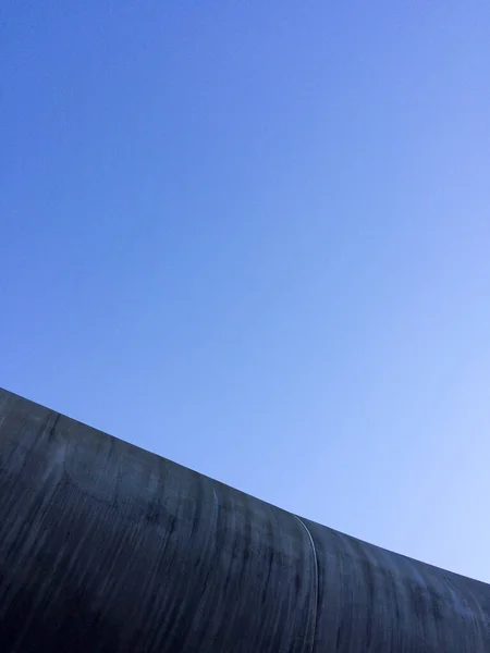 Nowoczesna architektura betonu abstrakcyjne tło z błękitnym niebem — Zdjęcie stockowe