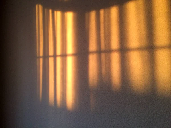 Luz solar dourada flui através de cortinas para fundo de design dourado — Fotografia de Stock