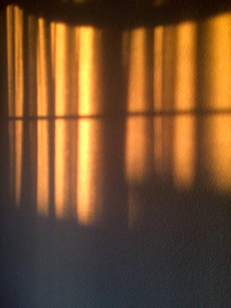 Luz del sol de oro arroyos a través de cortinas para el fondo de diseño dorado — Foto de Stock