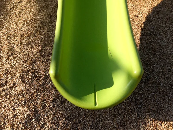 Neue moderne Spielgeräte grüne Kunststoffrutsche an Parkschule — Stockfoto
