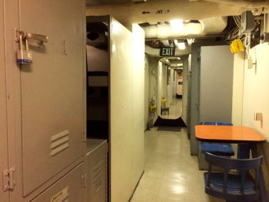 Koridor koridorunda gemide çıkış işareti ve dolap var.