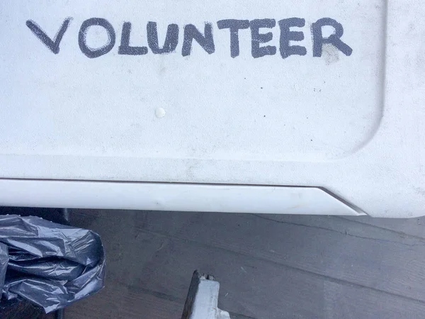 Знак добровольца, написанный от руки на крышке белой пластиковой ванны — стоковое фото