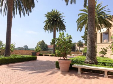 Pahalı bir tatil köyü, yeşil çimenler ve deniz kenarında ağaçlar.