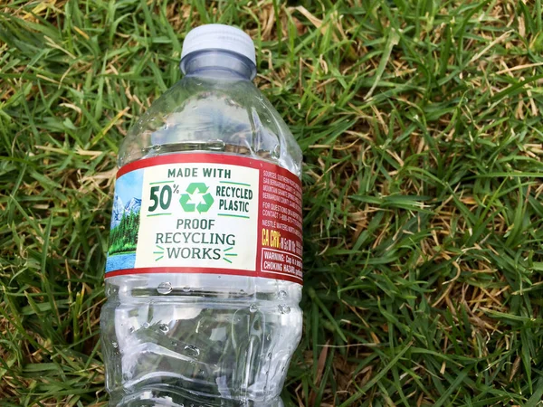 Plastik su şişesi yeşil çimen çevre kavramına yakın.