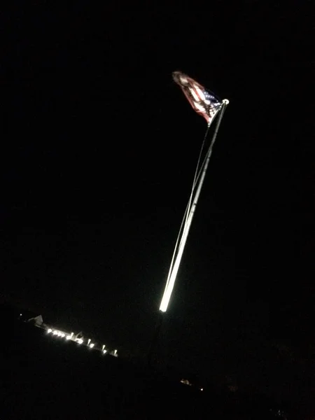 Bandera americana en el fondo del movimiento del asta de la bandera en la noche —  Fotos de Stock
