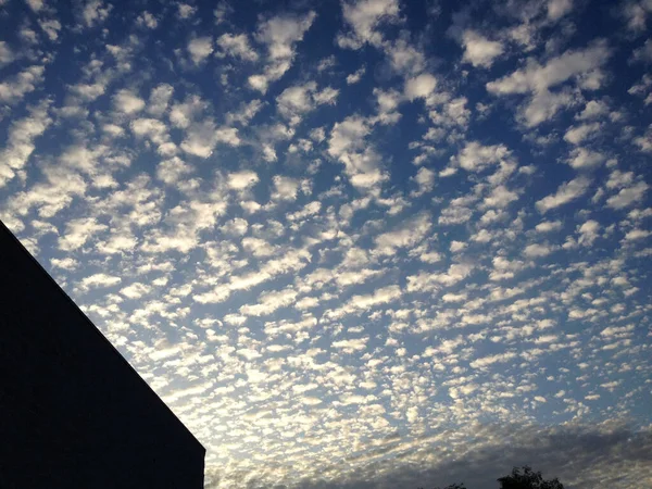 Blue sky cirrocumulus astrocumulus clouds with modern building — Stock Photo, Image