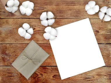 Boş kağıt, hediye kutusu ve tahta arka planda pamuk. Kış sıcacık minimalist konsepti, fotokopi alanı olan tatil listeleri. Üst görünüm.