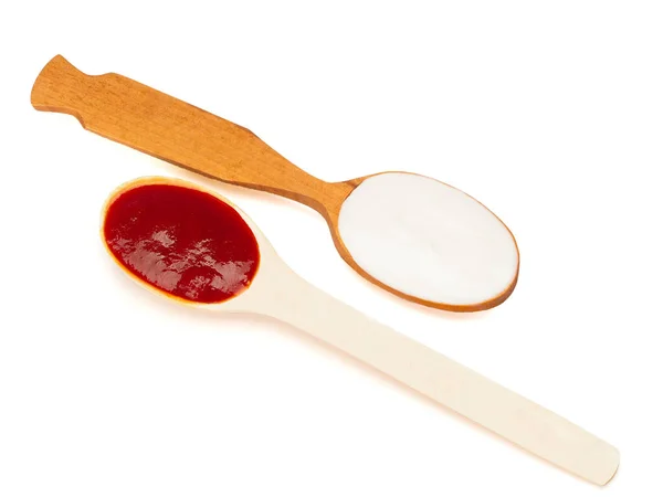 Liquid yogurt and ketchup in the wooden spoons — Stock Photo, Image