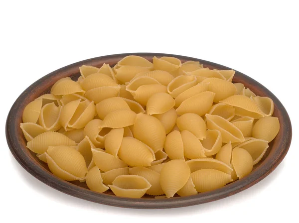 Italien torr rå pasta conchiglie på plattan. Närbild på vit bakgrund — Stockfoto