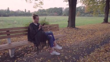 Bir sonbahar parkta bankta oturan kadın