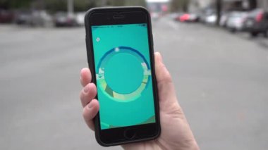 Kimliği belirsiz bir kadın tutun Pokemon oynayan bir telefon